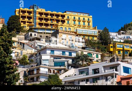 Taormina, Sicilia, Italia - 15 febbraio 2023: Vista panoramica delle case e delle residenze di Taormina sul pendio della roccia del Monte Tauro sulla riva del Mar Ionio Foto Stock
