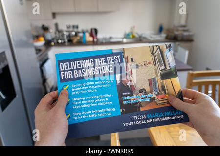 Un uomo/elettore del Regno Unito che tiene e legge un volantino delle elezioni locali conservatrici del maggio 2024 per un deputato di Basingstoke, Regno Unito. Tema: Elezioni locali, sede del consiglio Foto Stock