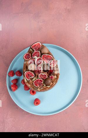 Uovo di Pasqua al cioccolato ripieno di tartufo brasiliano bianco e marmellata di lamponi, con spalmazione di franui 2. Foto Stock