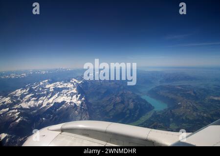 TORINO, ITALIA - 13 settembre 2019: Veduta aerea sopra le nuvole da un aereo che sorvola le Alpi svizzere, con cime ricoperte di neve e un fiume Foto Stock