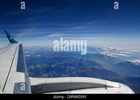 TORINO, ITALIA - 13 settembre 2019: Veduta aerea sopra le nuvole da un aereo che sorvola le Alpi svizzere, con cime ricoperte di neve e un fiume Foto Stock