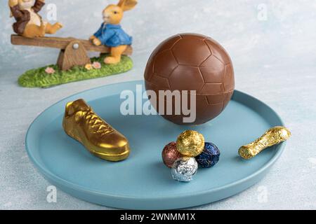 Uovo di Pasqua a forma di pallone da calcio ripieno di piccoli cioccolatini assortiti 1. Foto Stock