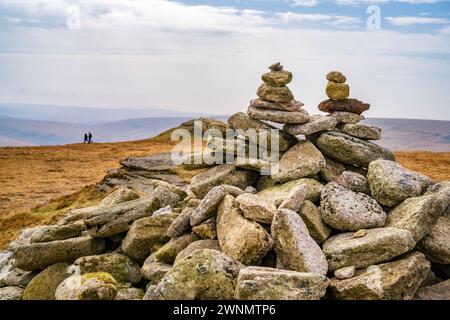 Rock Cairn sulla cima di High Willhays, il punto più alto di Dartmoor. Due escursionisti in background. Dartmoor National Park, Devon, Inghilterra, Regno Unito. Foto Stock