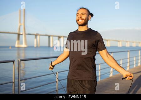 L'atleta europeo sorridente salta con la corda che salta all'aperto Foto Stock