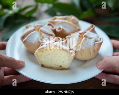 Piatto di soffioni Abruzzesi torte in mano, focalizzazione selettiva. Classici cupcake italiani appena sfornati Foto Stock