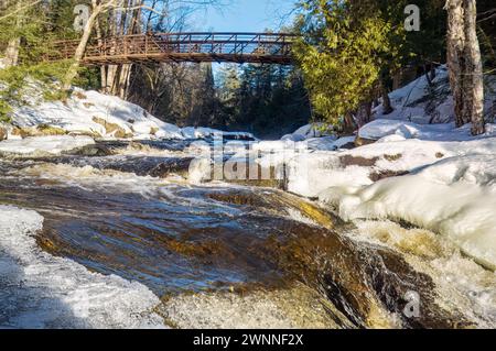 Vista panoramica invernale delle Stubb's Falls nell'Arrowhead Provincial Park in inverno. Il ghiaccio si sta sciogliendo a causa della temperatura invernale insolitamente calda Foto Stock