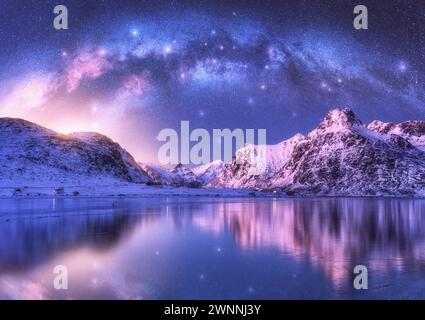 La via Lattea si affaccia sulla costa del mare e sulle montagne innevate Foto Stock