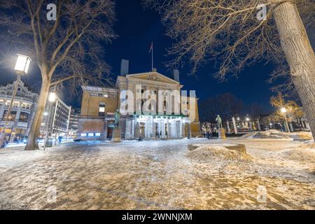 Teatro nazionale di Oslo durante la notte d'inverno a febbraio. Bellissimo edificio d'epoca nel centro di oslo, in una notte fredda. Neve e ghiaccio per la strada i Foto Stock