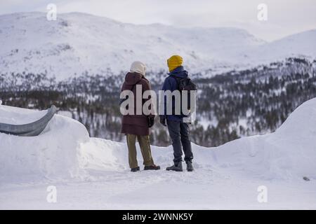 Vista posteriore della coppia norvegese che si gode la vista del magnifico paesaggio montano a Mjolfjell, piccola città sulla famosa linea ferroviaria Bergen - Oslo all'inizio Foto Stock