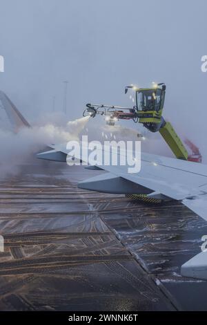 Sbrinamento o sbrinamento di un aeromobile prima del decollo. Misure di sicurezza a basse temperature ambiente in aeroporto, per evitare il congelamento delle superfici di controllo. Foto Stock