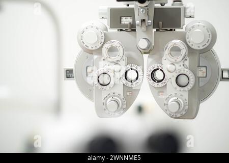 primo piano di phoropter, strumento specializzato utilizzato negli esami oculari per misurare gli errori di rifrazione e determinare le prescrizioni degli occhiali, medico oculistico Foto Stock