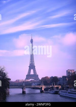 Torre Eiffel a Parigi, in Francia, vista dal fiume Senna al crepuscolo, con il cielo serale viola e la classica atmosfera romantica della città Foto Stock