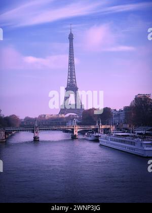 Torre Eiffel a Parigi, in Francia, vista dal fiume Senna al crepuscolo, con barche e luce viola soffusa sulla capitale francese Foto Stock