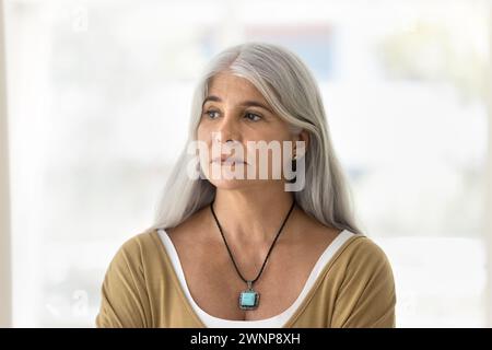 Grave depressa donna latina anziana dai capelli grigi che guarda lontano Foto Stock