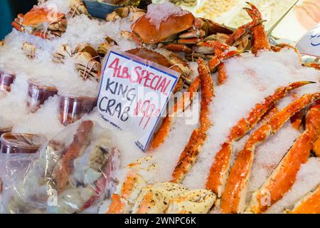 Granchio reale fresco su ghiaccio in vendita al famoso mercato del pesce Pike Place nel centro di Seattle, Washington Foto Stock