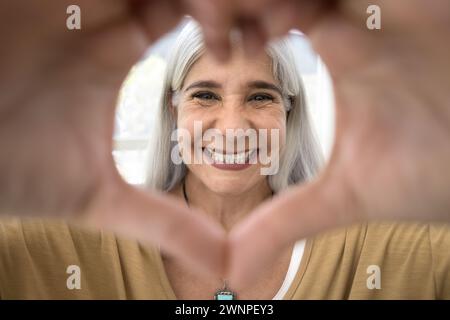 Allegra bionda dai capelli grigi anziana donna latina che guarda la macchina fotografica Foto Stock