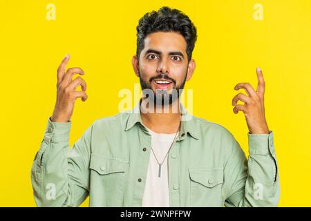 Oh mio Dio, Wow. Vincitore entusiasta e sorpreso che alza la mano a sorpresa guardando la telecamera con grandi occhi, scioccato dall'improvvisa vittoria che celebra il successo buone notizie. Ragazzo su sfondo giallo Foto Stock