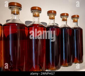 Diversi colori e età di liquori cognac in bottiglia in distilleria, regione dei vini bianchi Cognac, Charente, visita di un vecchio distillatore di liquori, Foto Stock