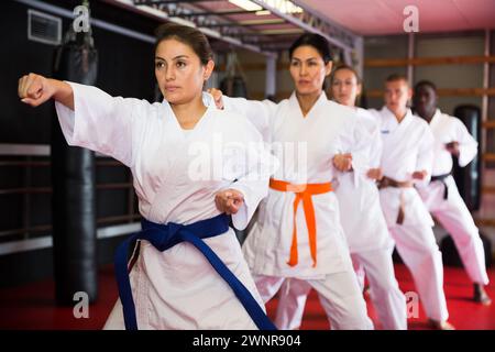 Uomini e donne polietnici in kimono esercizio kata Foto Stock