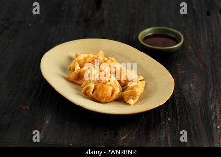 Mandorle di Kimchi coreani fritti con salsa piccante, su un tavolo di legno Foto Stock