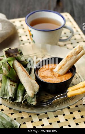 L'OTAK-Otak Bakar è una tradizionale torta di pesce indonesiana a base di pesce macinato avvolto in una foglia di banana, alla griglia e servito con salsa di arachidi. Foto Stock