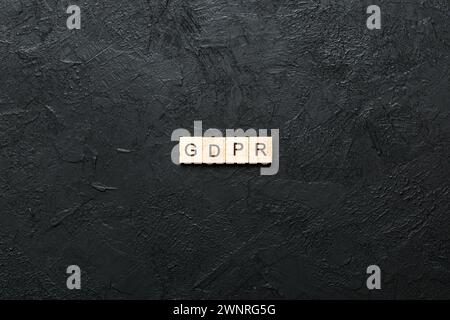 Parola GDPR scritta su blocco di legno. Testo di regolazione generale della protezione dei dati su tabella di cemento per il vostro desing, concetto. Foto Stock