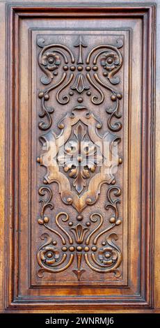 Pannello di legno intagliato su una porta Foto Stock
