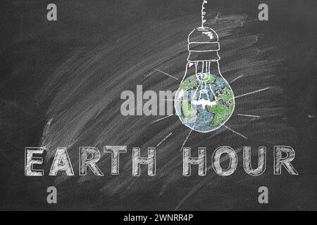 Lampadine con scritta EARTH HOUR disegnate a mano in gesso su una lavagna scolastica. Salvare il mondo. Salvate il nostro pianeta. Foto Stock
