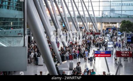 Airport Düsseldorf, Nordrhein Westfalen, Deutschland Europa - Impressionen am Flughafen - Warteschlangen am Check-in im Terminal und genervte Urlauber Symbolbild: Gepäckabgabe, Flugsteig, Flugzeug, Abflug, Ankunft, Flugplan, Reisevorbereitung, Flughafenpersonal, Gate, Verspätung, Reisegruppe, Passkontrolle, Zollkontrolle, Gepäckband, Flughafenlounge, Duty-Free-Shop, Sicherheitspersonal, Boarding-Prozess, Flughafenbus, Rolltreppe, Gepäckwagen, Flugreisender, Reisegepäck, Reisepasskontrolle, Flugverspätung, Terminalgebäude, Passagierabfertigung, Flugziel, Flughafenterminal, Anzeigetafel, Reise, Foto Stock