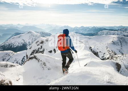 Un alpinista cammina con attenzione attraverso un crinale di montagna Foto Stock