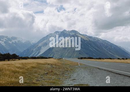 Le nuvole di tempesta si muovono sopra le vette innevate delle montagne nella nuova Zelanda rurale Foto Stock