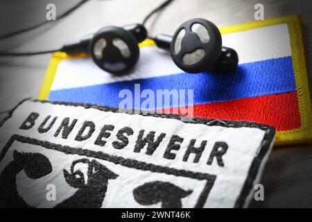 Bundeswehr-Aufnäher und Kopfhörer auf Russland-Fahne, Symbolfoto Taurus-Abhöraffäre *** Bundeswehr patch e cuffie sulla bandiera della Russia, foto simbolica Taurus wiretapping Affair Foto Stock