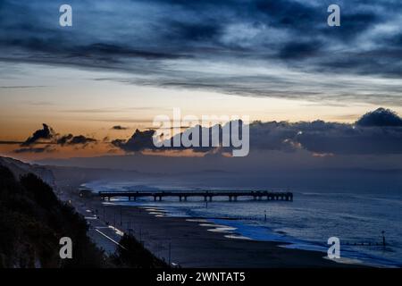 Vista dall'Overcliff, Boscombe fino al molo prima che sorga il sole. Orientamento orizzontale con spazio per il testo. Nessuna persona visibile. Foto Stock