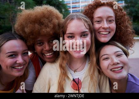 Gruppo eterogeneo di donne con teste unite che sorridono unite per l'uguaglianza e il diritto delle donne. Foto Stock