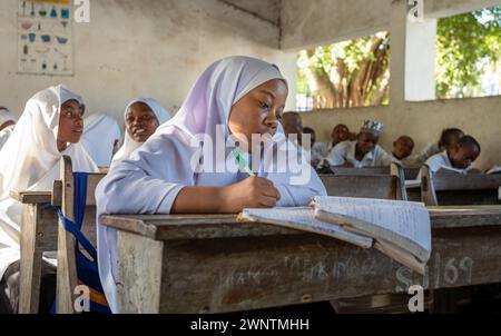 Una ragazza musulmana e altri studenti maschi e femmine in una classe di inglese alla Jambiani Secondary School di Jambiani, Zanzibar, Tanzania. Foto Stock