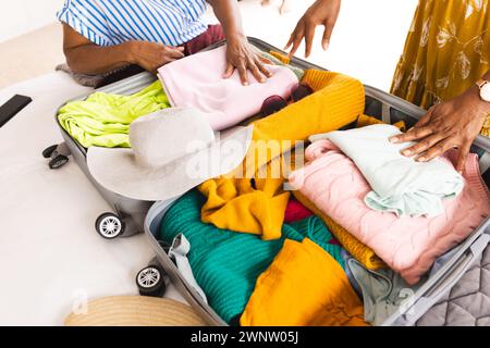Una donna afroamericana anziana e una donna birazziale anziana fanno una valigia Foto Stock