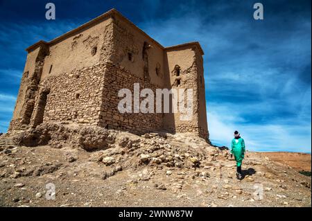 Uomo che cammina davanti all'edificio storico di Ait Benhaddou, Marocco Foto Stock