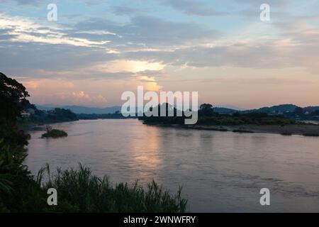 Il fiume Mekong scorre tra il Laos e la Thailandia al tramonto. Vista dalla città di Houayxay sul lato del Laos. Foto Stock