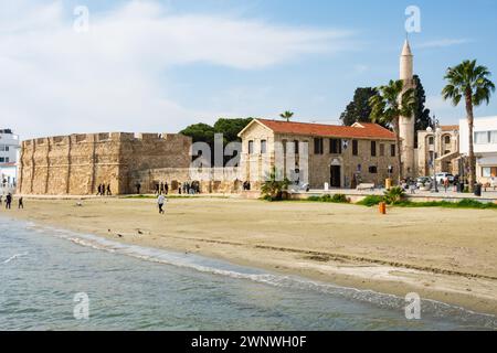 Forte di Larnaca e minareto della grande Moschea Djami Kebir Pavlou Vslsmaki. Spiaggia invernale vuota. Larnaca, Cipro. Febbraio 2024 Foto Stock