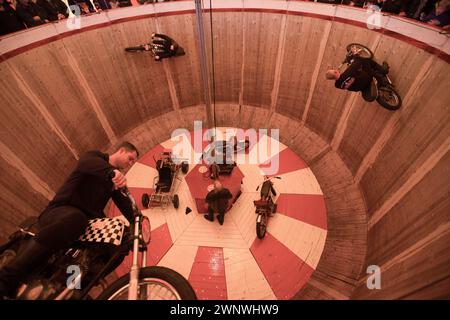 24/04/16 i cavalieri di sfida-demonio della Ken Fox Troupe caricano intorno al muro della morte sulle loro moto d'epoca al Carole Nash International Foto Stock