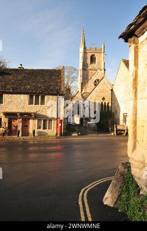 Il sole autunnale sulla chiesa di St Andrews e le case nel centro di Castle Combe, Wiltshire, una volta votato il villaggio più bello d'Inghilterra. Foto Stock
