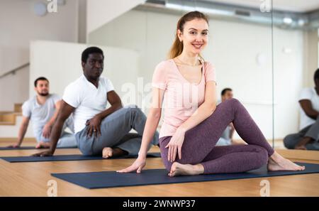 Persone che esercitano signore dei pesci asana in palestra Foto Stock