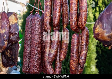Le salsicce essiccate prodotte e affumicate tradizionalmente dai serbi in un mercato agricolo nel villaggio di Kacarevo, il festival della bacon gastronomica e dei prodotti a base di carne secca si tiene ogni anno Foto Stock