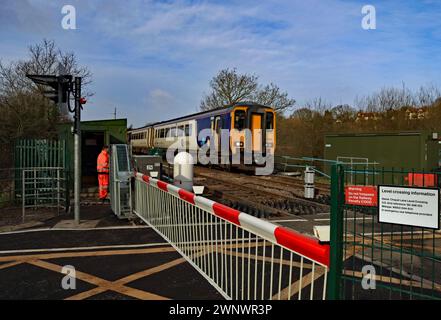 Un treno del Nord attraversa il passaggio a livello a Chapel Lane vicino a Parbold nel Lancashire, dove sono state installate nuove barriere automatiche. Foto Stock