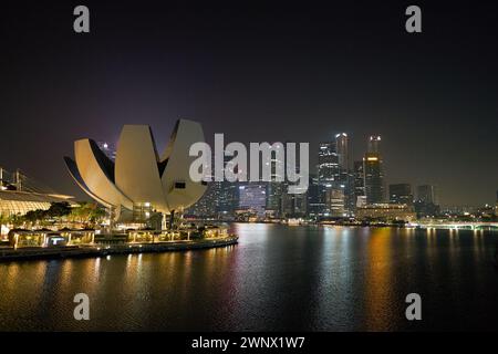 SINGAPORE - 6 NOVEMBRE 2023: Vista del Museo delle Scienze dell'Arte con lo skyline di Singapore sullo sfondo di notte. Foto Stock