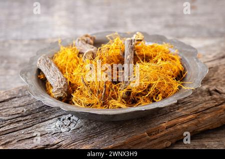 Radice di liquirizia, fibra di liquirizia in ciotola su fondo rustico ( glycyrrhiza glabra ) Foto Stock