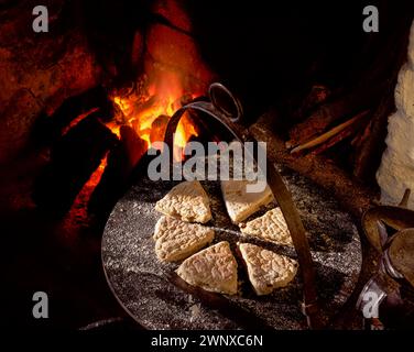 Fruit Soda Farles su una griglia sopra un fuoco aperto in un tradizionale cottage irlandese Foto Stock