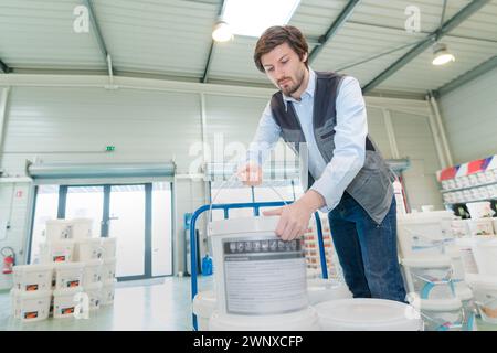 uomo che sceglie la vernice in un negozio di ferramenta Foto Stock