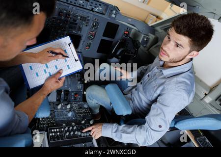 ingegnere aerodinamico maschio con clipboard che lavora in cockpit Foto Stock