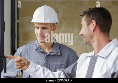 due operai che ispezionano una porta Foto Stock